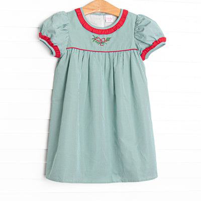  This dress features a green gingham print, red ruffle trim, and a holly embroidery. 