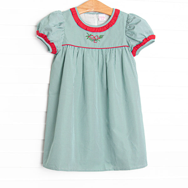  This dress features a green gingham print, red ruffle trim, and a holly embroidery. 