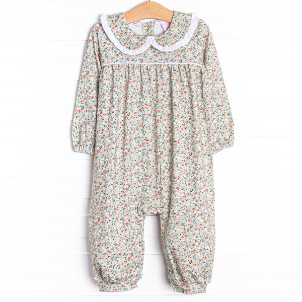  This romper features a green floral print, a peter pan collar with white ruffle trim, and snaps on the stride. 