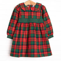  This dress features a red plaid print, a green sash, and a peter pan collar. 
