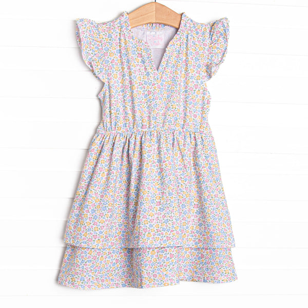 This dress features a yellow floral print, flutter sleeves, and a bow sash in the back.