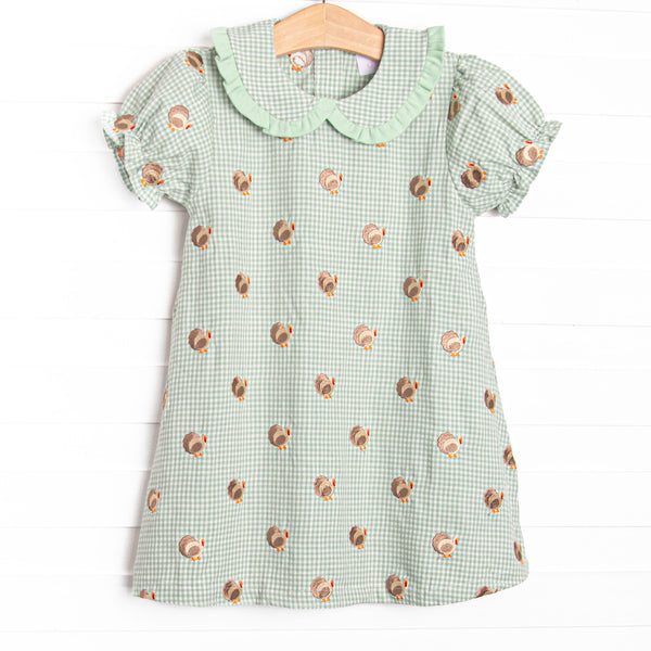 This dress features sage gingham material, a turkey embroidered design, and a fun trimmed collar.