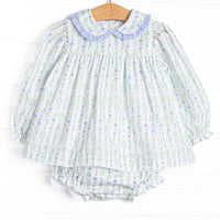 This set features a floral print, a peter pan collar with blue ruffle trim, and matching diaper cover.