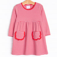  The dress features front ruffle pockets, red&nbsp;trim, and&nbsp;red stripes. 