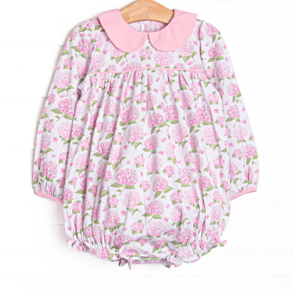 This bubble features a pink hydrangea print, a pink Peter Pan collar, and snaps on the stride.
