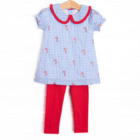 This set features a blue gingham print, peter pan collar with red ruffle trim, and candy cane embroideries. Coordinating red leggings to match.