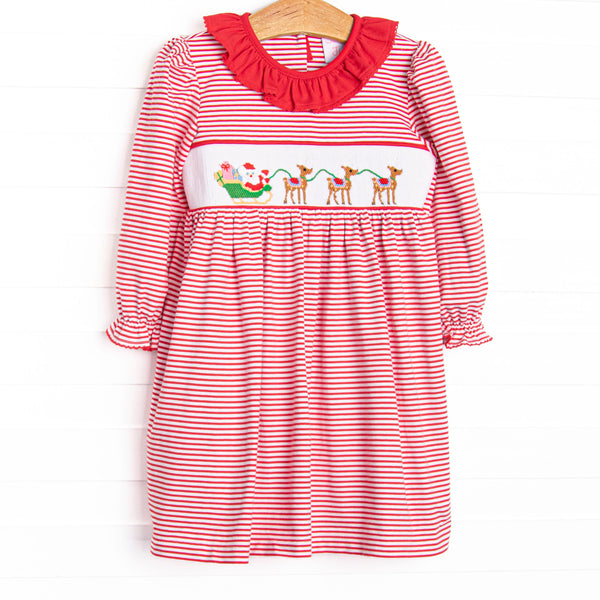This dress features a red striped print, a red ruffle collar, and a smocking of Santa's Sleigh.