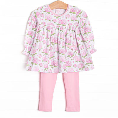 This set features a long sleeve top in a pink hydrangea print, pink trim, and a front pocket. Coordinating pink knit leggings to match.