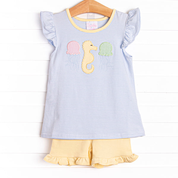 This set features a flutter sleeves top in a blue striped print, a seahorse applique, and yellow ruffle shorts to match.