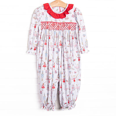 This romper features a Christmas print, dainty smocking, and red ruffle collar.