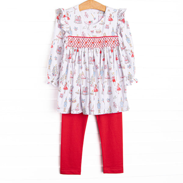 This set features a Christmas print, dainty smocking, and red leggings to match.