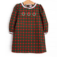  This dress features a red plaid print, white ruffles, and a trio of wreath embroideries. 