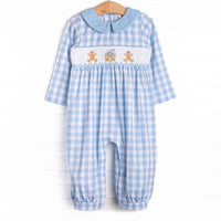 This romper features a blue check print, a blue peter pan collar, and a ginger snap smocking.