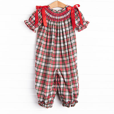  This romper features a red plaid print, puff sleeves, and red satin bows. 