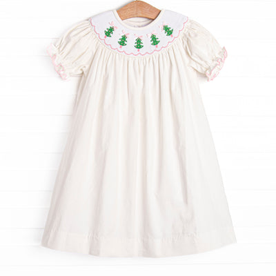  This dress features a white corduroy material, puff sleeves, and Christmas tree smockings. 