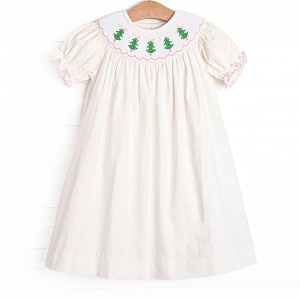  This dress features a white corduroy material, puff sleeves, and Christmas tree smockings. 