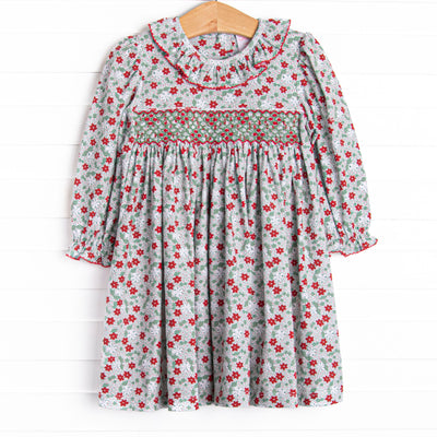 This dress features a red and green floral print, ruffle collar, and a dainty geometric smocking.