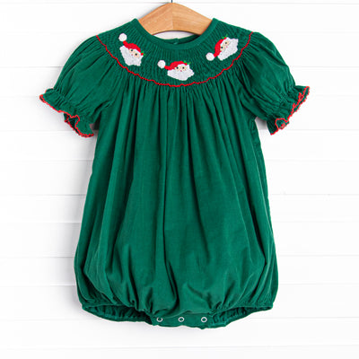 This bubble features a green corduroy material, puff sleeves with red picot trim, and Santa Claus smockings