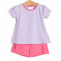  The set features a purple stripe top, pink trim, and pink ruffle shorts to match. 
