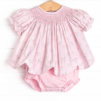  This set features a rose print, puff sleeves, and a dainty smocking. Coordinating pink diaper cover to match. 