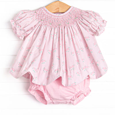  This set features a rose print, puff sleeves, and a dainty smocking. Coordinating pink diaper cover to match. 