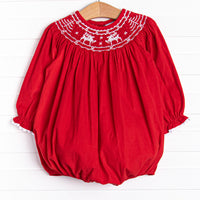 his bubble features a red corduroy material, white ric rac trim on the hem of the sleeves, and reindeer smockings.
