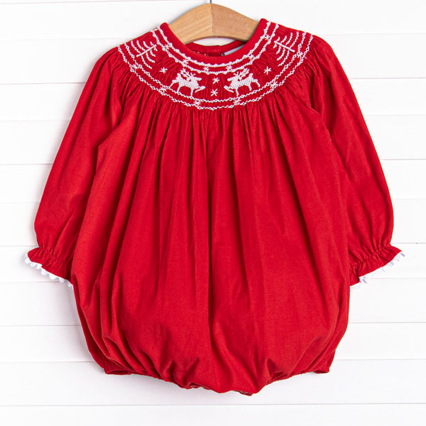 his bubble features a red corduroy material, white ric rac trim on the hem of the sleeves, and reindeer smockings.