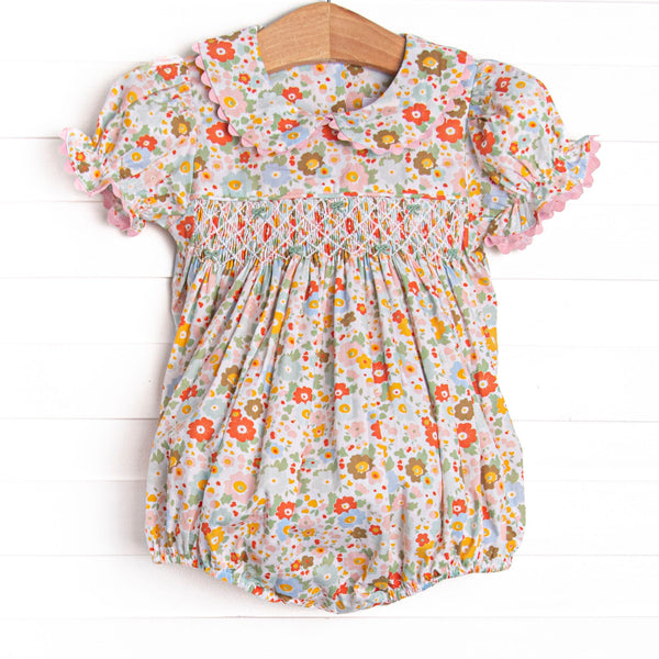 This bubble features a pink floral print, puff sleeves, a dainty smocking.