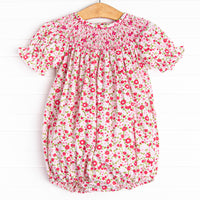  This bubble features a pink floral print, snaps on the stride, and a floral smocking. 