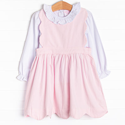  This set features a long sleeve top with a ruffle collar and a pink corduroy jumper with a scalloped edge. 