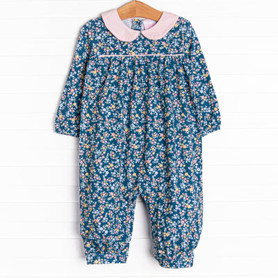 This romper features a blue floral print, a pink peter pan collar, and snaps on the stride.