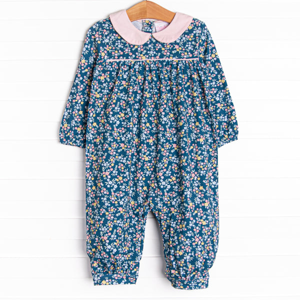This romper features a blue floral print, a pink peter pan collar, and snaps on the stride.