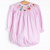  The bubble featured in pink gingham boasts adorable long puff sleeves, snaps in the stride to make changing a breeze, and a smocked Christmas scene. 