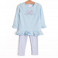 This set features a blue ruffle top with a blue bow applique and blue striped leggings to match.