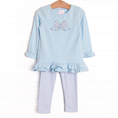 This set features a blue ruffle top with a blue bow applique and blue striped leggings to match.