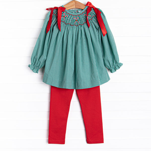 This set features a green gingham print, red satin bows in the shoulders, and candy cane smockings. Coordinating red leggings to match.