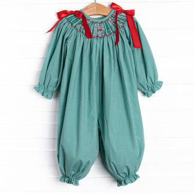 This romper features a green gingham print, red satin bows in the shoulders and candy cane smockings. 