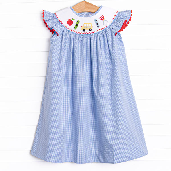 This dress features a blue mini gingham print, flutter sleeves, and a back to school smocking.