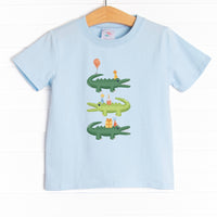  The shirt is featured in four colors; White, Heather Gray, Ballerina Pink, and Soft Blue with a crocodile birthday graphic. 