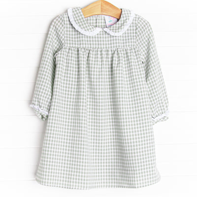 This dress is featured in a green gingham print, with a peter pan collar with a ruffle detail.