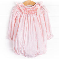 A long sleeve bubble with a pink smocking and pink bow details on the shoulders.&nbsp;
