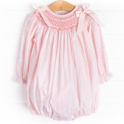 A long sleeve bubble with a pink smocking and pink bow details on the shoulders.&nbsp;
