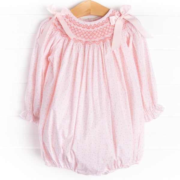 A long sleeve bubble with a pink smocking and pink bow details on the shoulders.&nbsp;