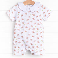  The romper features a Peter Pan collar, snaps at the stride to make changing a breeze, and a football filled print. 