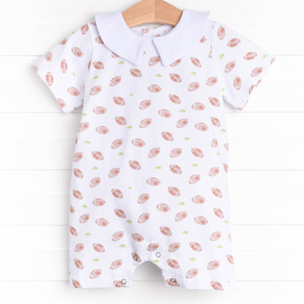  The romper features a Peter Pan collar, snaps at the stride to make changing a breeze, and a football filled print. 
